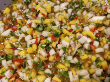 Chopped mango, onion, red pepper, cilantro, and herbs mixed together in a fresh salsa.